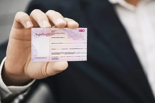مردی که کارت اقامت گرجستان را در دست دارد
